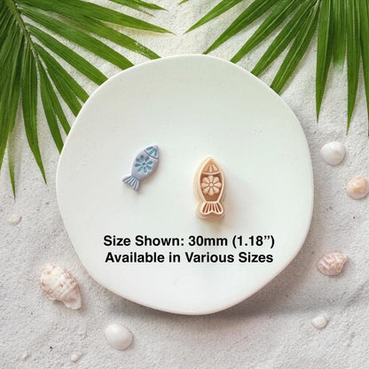 Fish cutter and finished clay pieces with size text 30mm on white plate coastal background