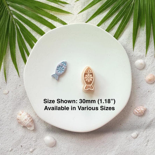 Fish cutter and finished clay pieces with size text 30mm on white plate coastal background