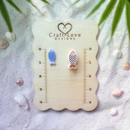 Fish clay cutter and finished pieces displayed on wooden sizing board with coastal decor