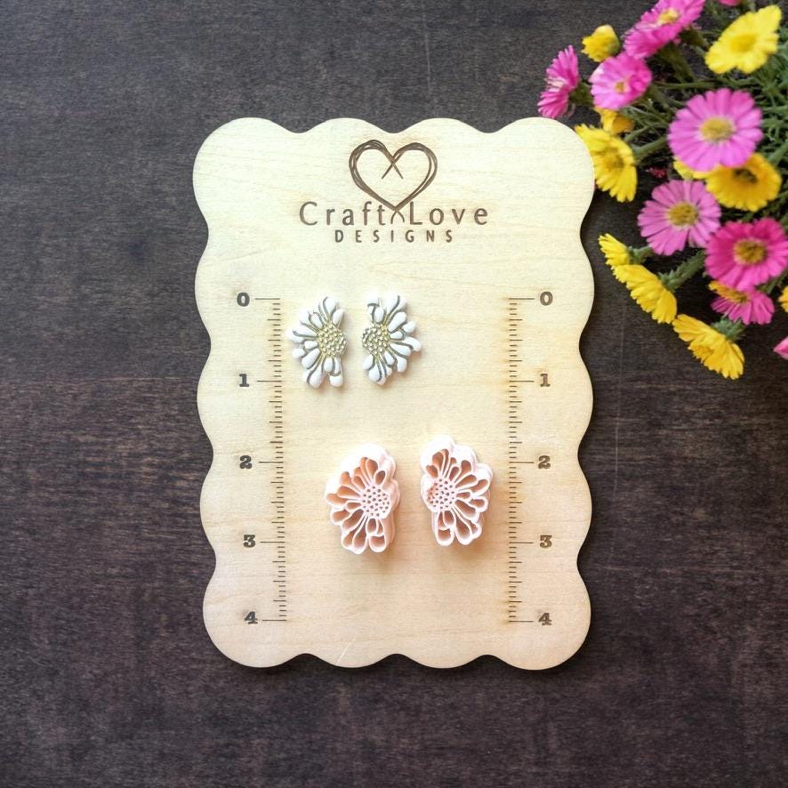 daisy flower polymer clay cutters displayed on wooden sizing board