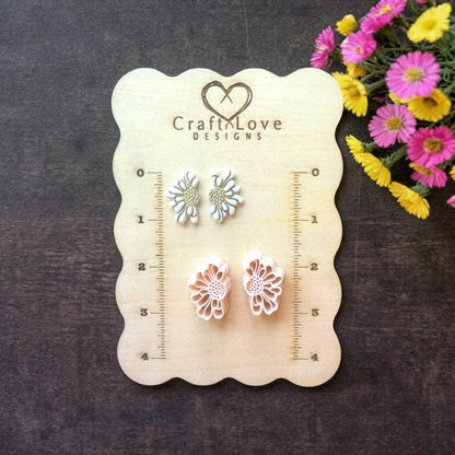 daisy flower polymer clay cutters displayed on wooden sizing board
