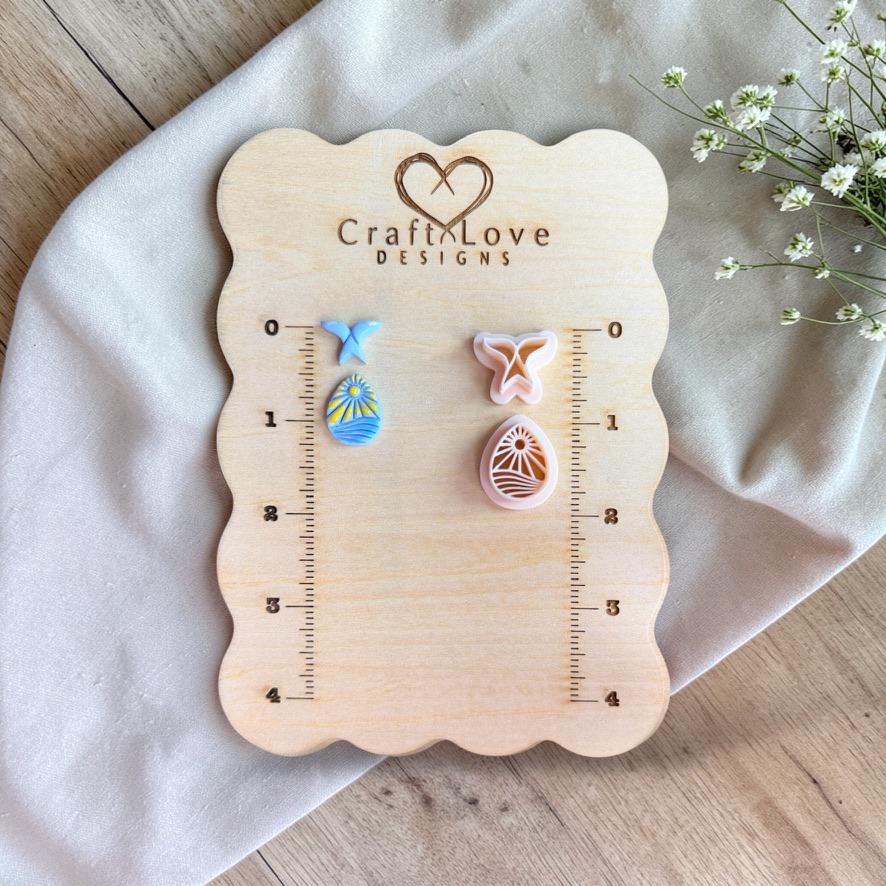 Whale tail and ocean cutters with finished clay pieces displayed on wooden measurement board