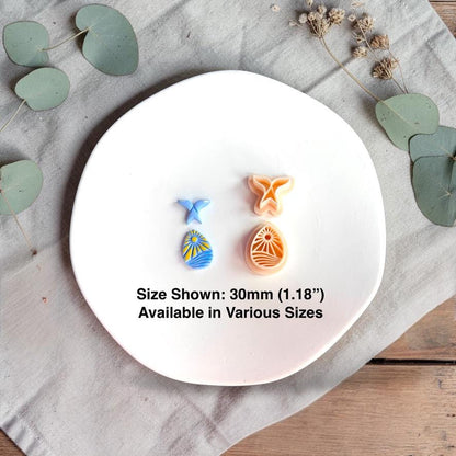 Whale tail and ocean cutters with clay pieces showing 30mm size reference on white plate