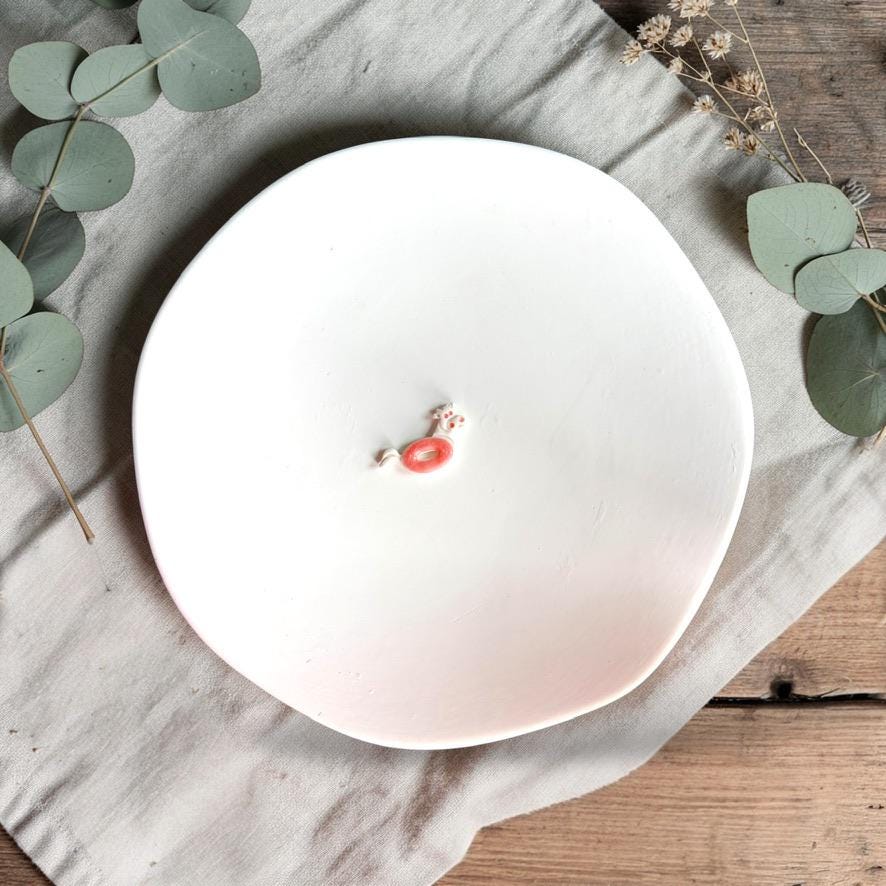 Small clay cow floatie design in pink tones on white background