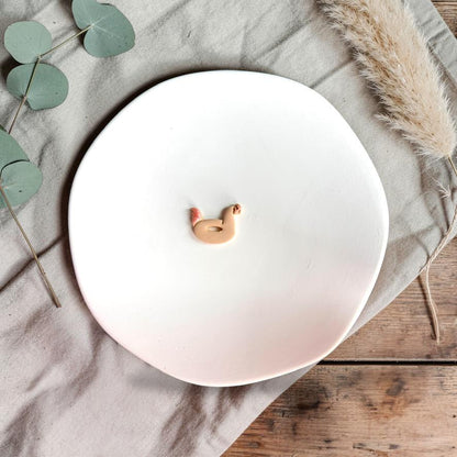 Small clay chicken float design in soft peach tones on white background