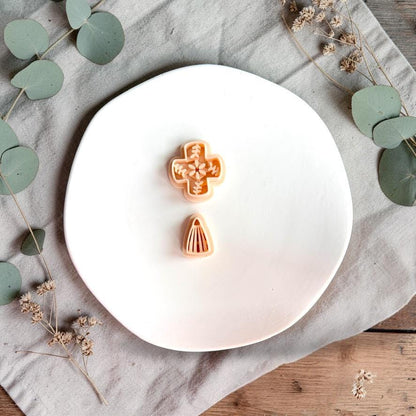 Ceramic tile style polymer clay cutter with matching drop piece on white plate