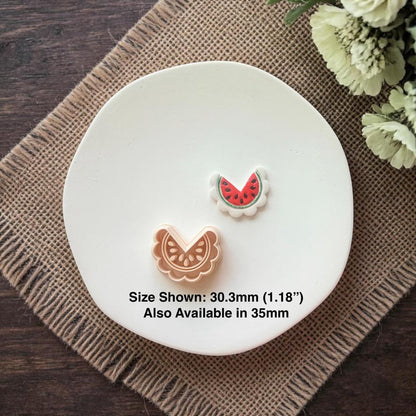 Polymer clay cutter and finished watermelon earrings displayed together with size