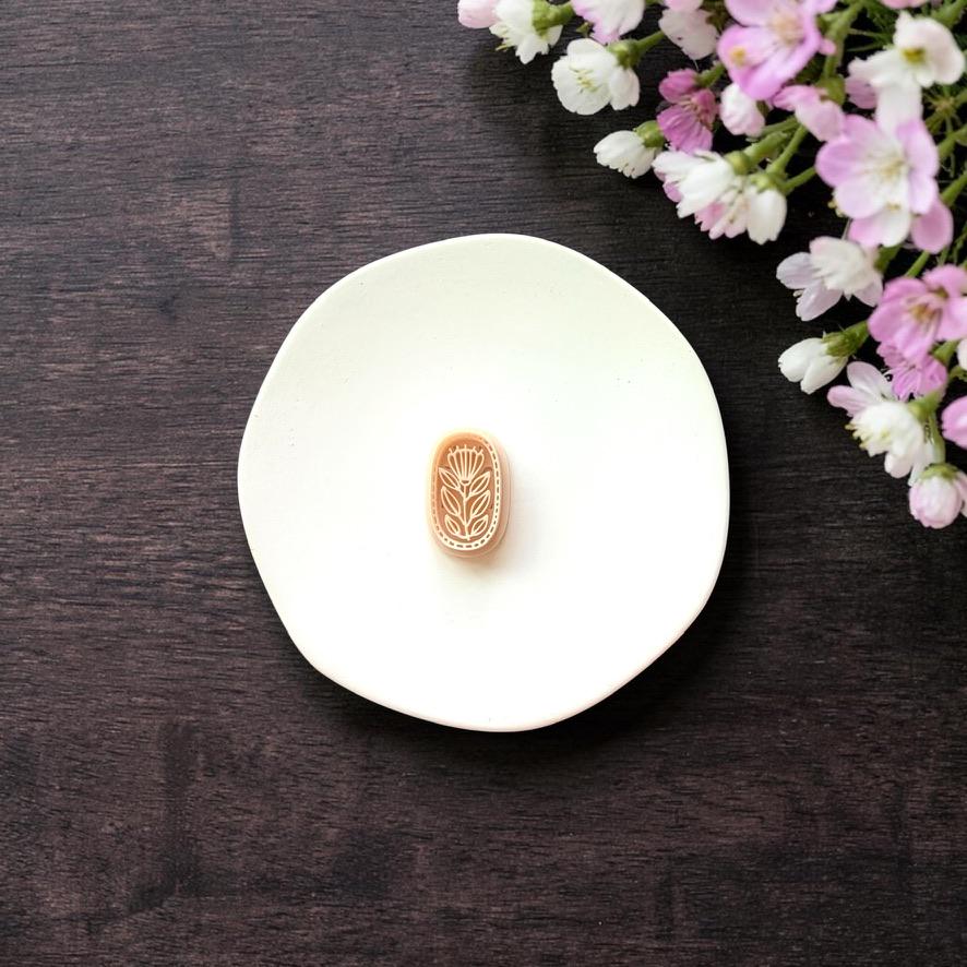 Oval botanical clay cutter on white background with flower detail