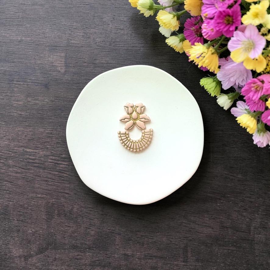 Assembled floral and fan arch clay piece on white background