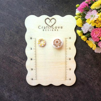 Mini daisy flower polymer clay cutters displayed on wooden sizing board
