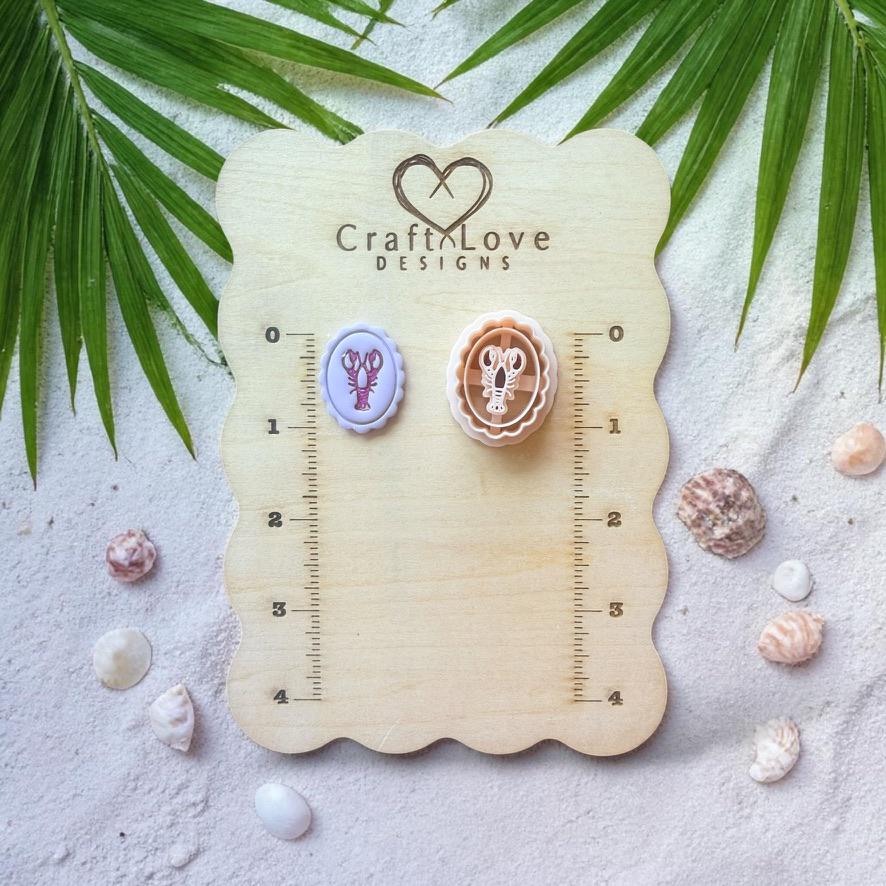 Lobster cameo cutter and clay pieces displayed on wooden sizing board with beach decor