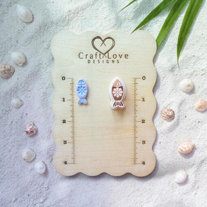 Fish clay cutter and finished pieces displayed on wooden sizing board with beach decor