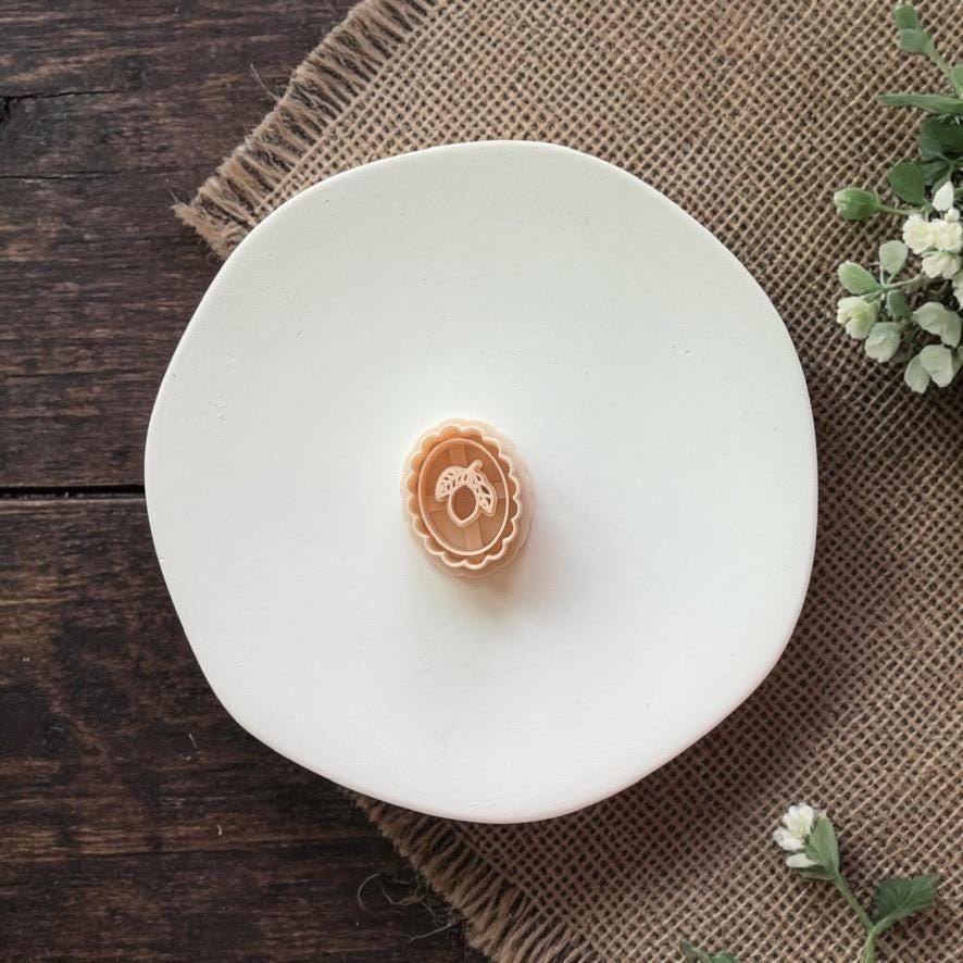 ornate lemon cameo clay piece on white plate burlap background