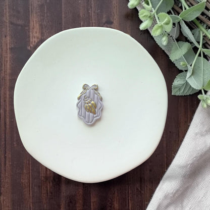 finished seashell cameo clay piece with bow detail on white plate