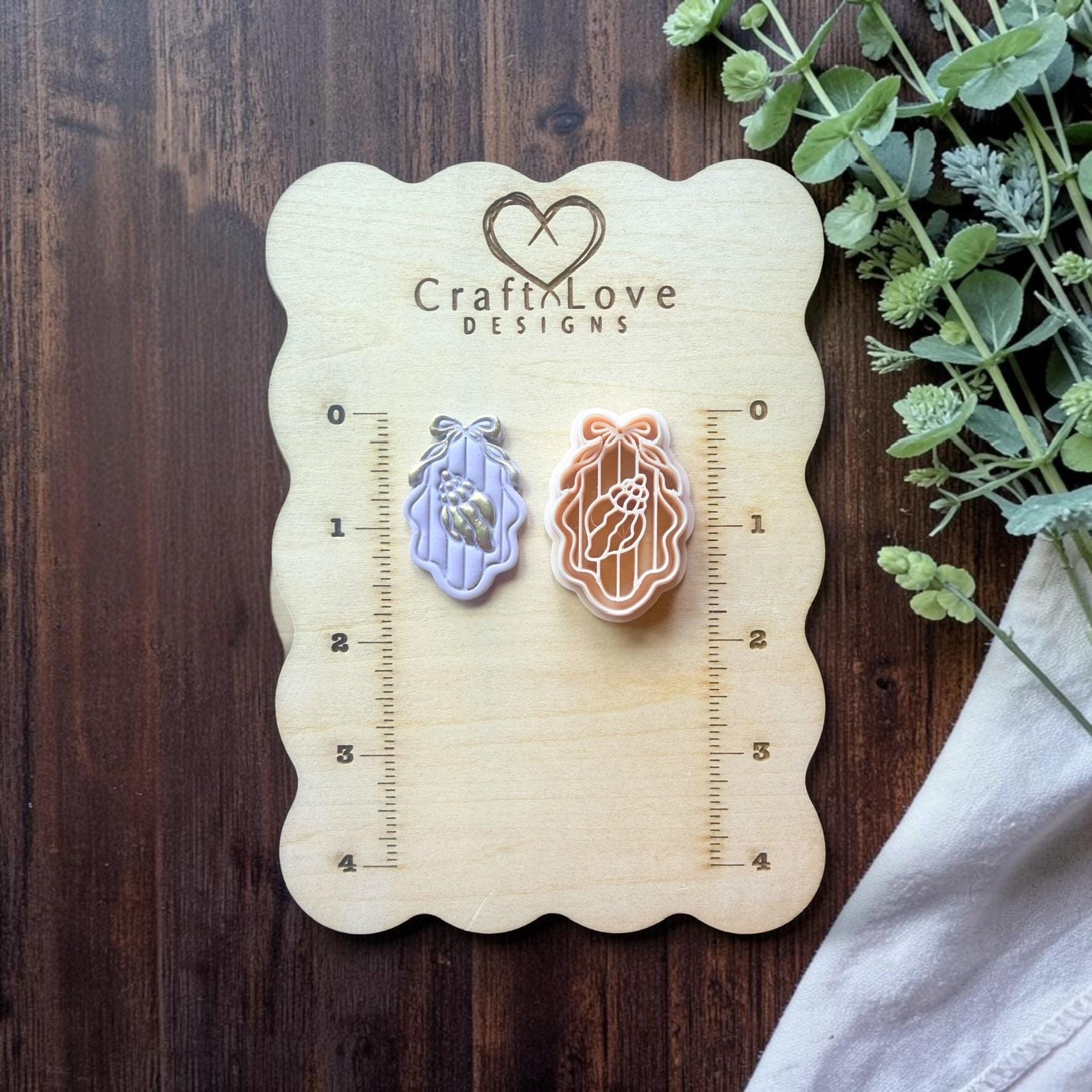 seashell cameo cutter displayed on ruler board for size reference