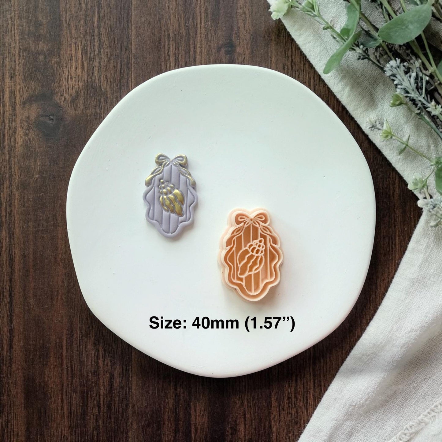 cutter and finished shell cameo shown together on white plate