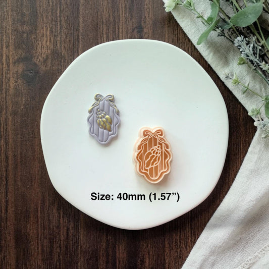 cutter and finished shell cameo shown together on white plate
