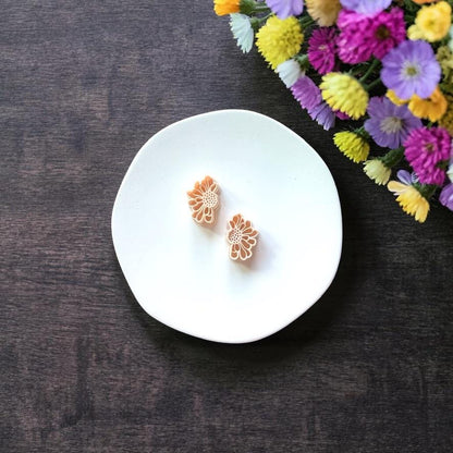 Small daisy clay piece with open center on white background
