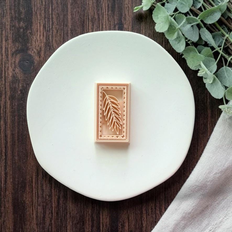 rectangular leaf polymer clay cutter on white plate with wood background and greenery