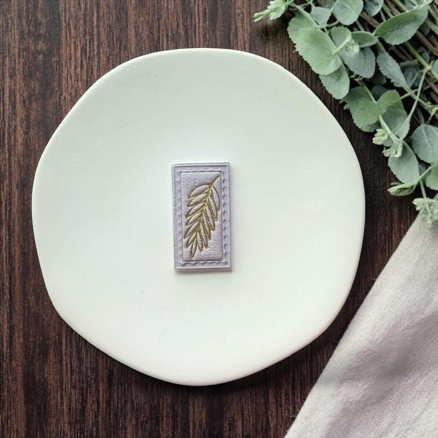 finished rectangular leaf clay piece in light color on white plate