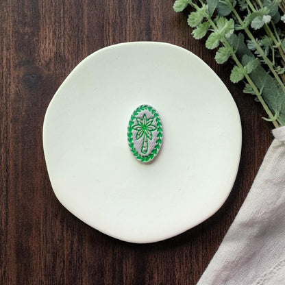 finished palm tree clay piece with green details on white plate