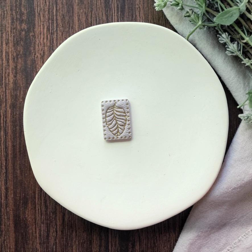 finished leaf clay piece in neutral color on white plate