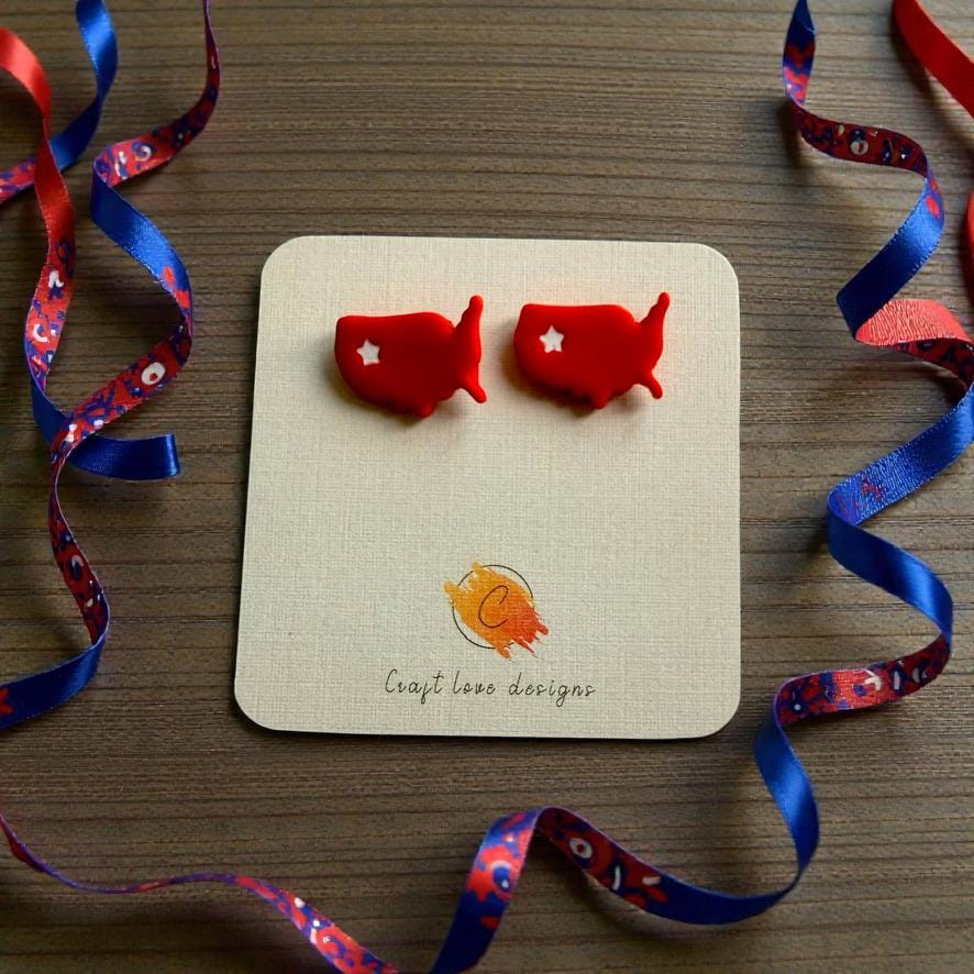 Handmade patriotic USA map stud earrings displayed on jewelry card with festive red white and blue ribbon decorations