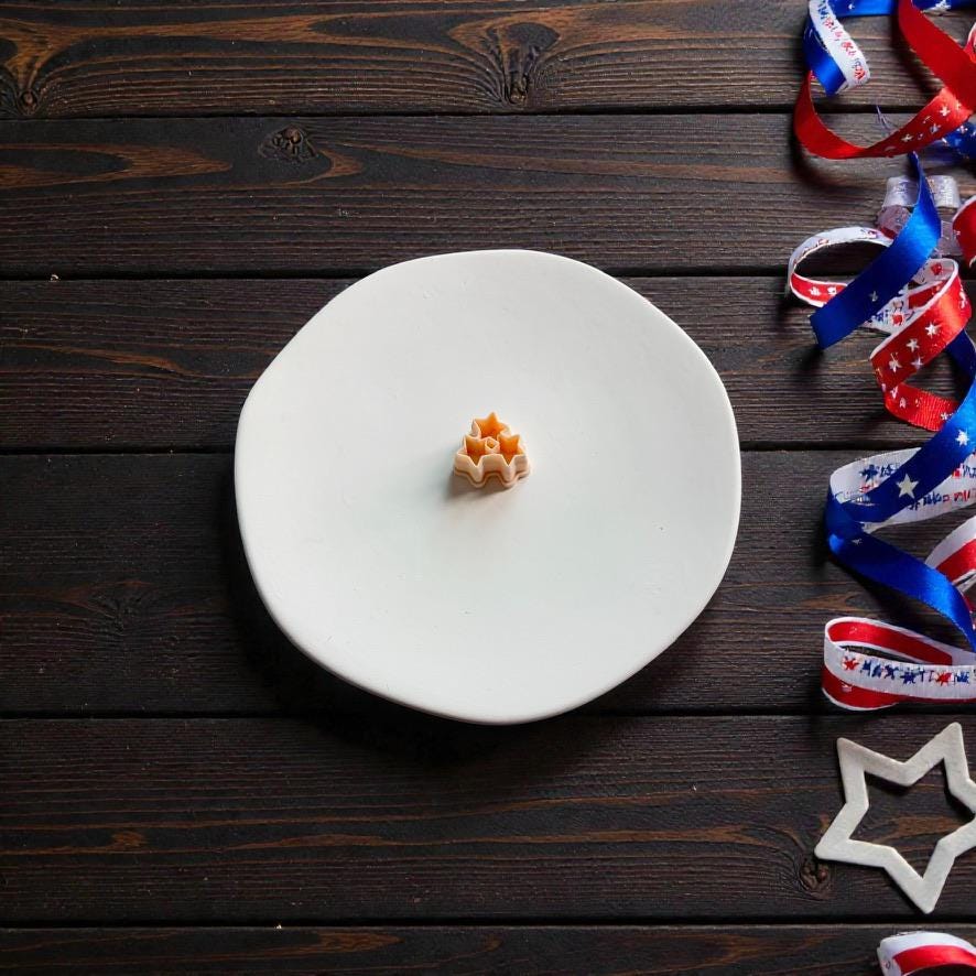 Mini patriotic star clay cutter displayed on white clay surface with Americana themed decorations