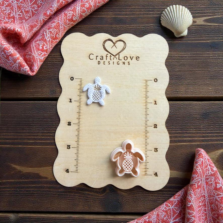 Sea turtle polymer clay cutter with pineapple center design displayed beside finished turtle clay piece on CraftLove Designs measurement board