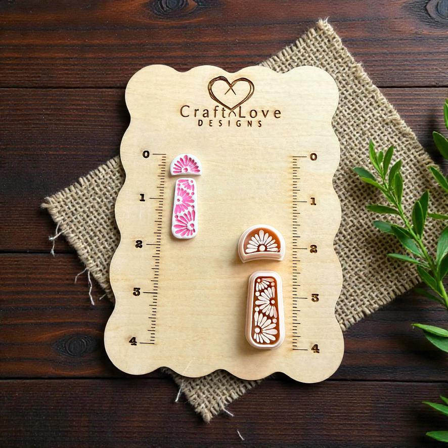 Boho daisy polymer clay cutter set displayed on CraftLove Designs wooden measurement board with burlap fabric and greenery accents