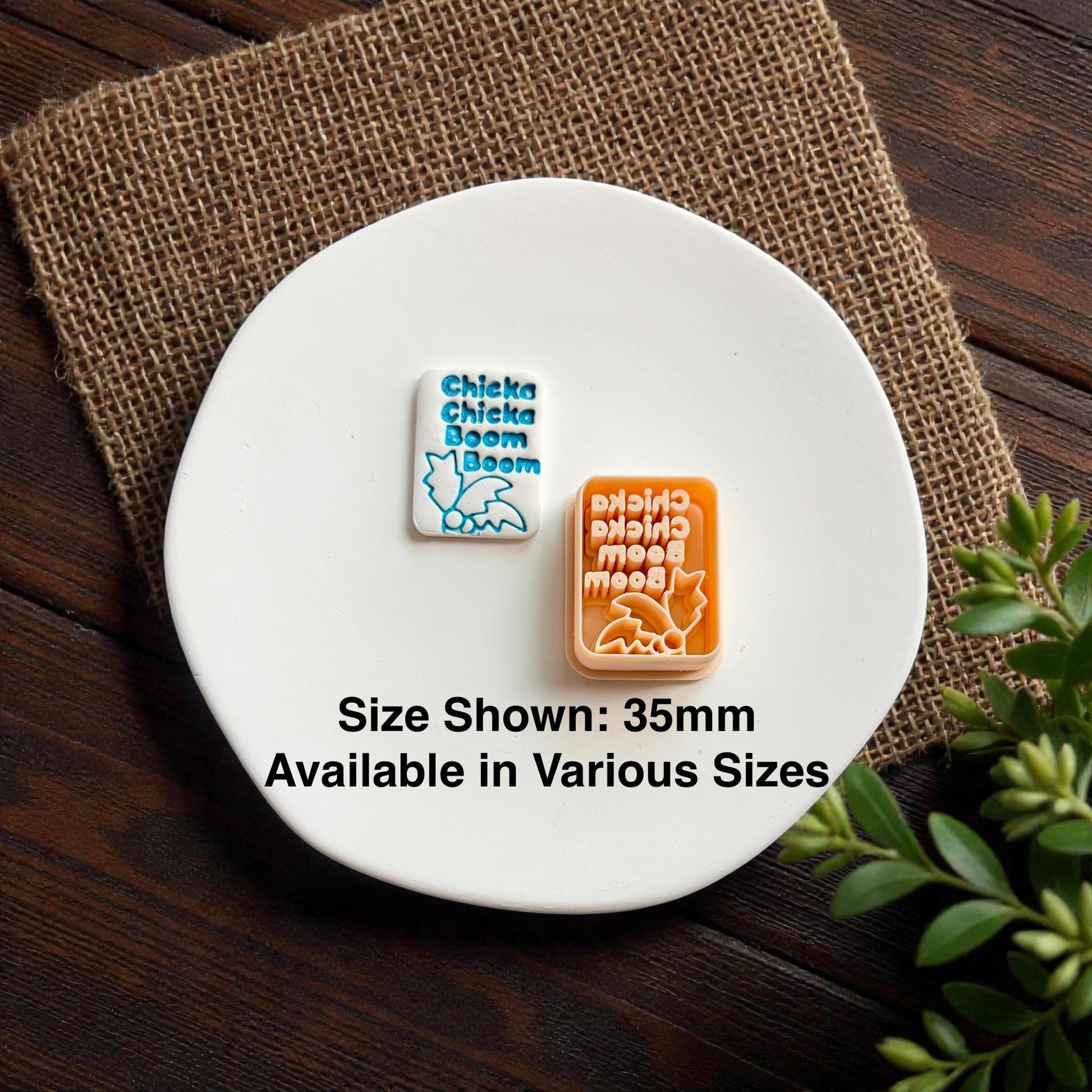 Polymer clay cutter and finished alphabet themed jewelry piece displayed together on ceramic plate