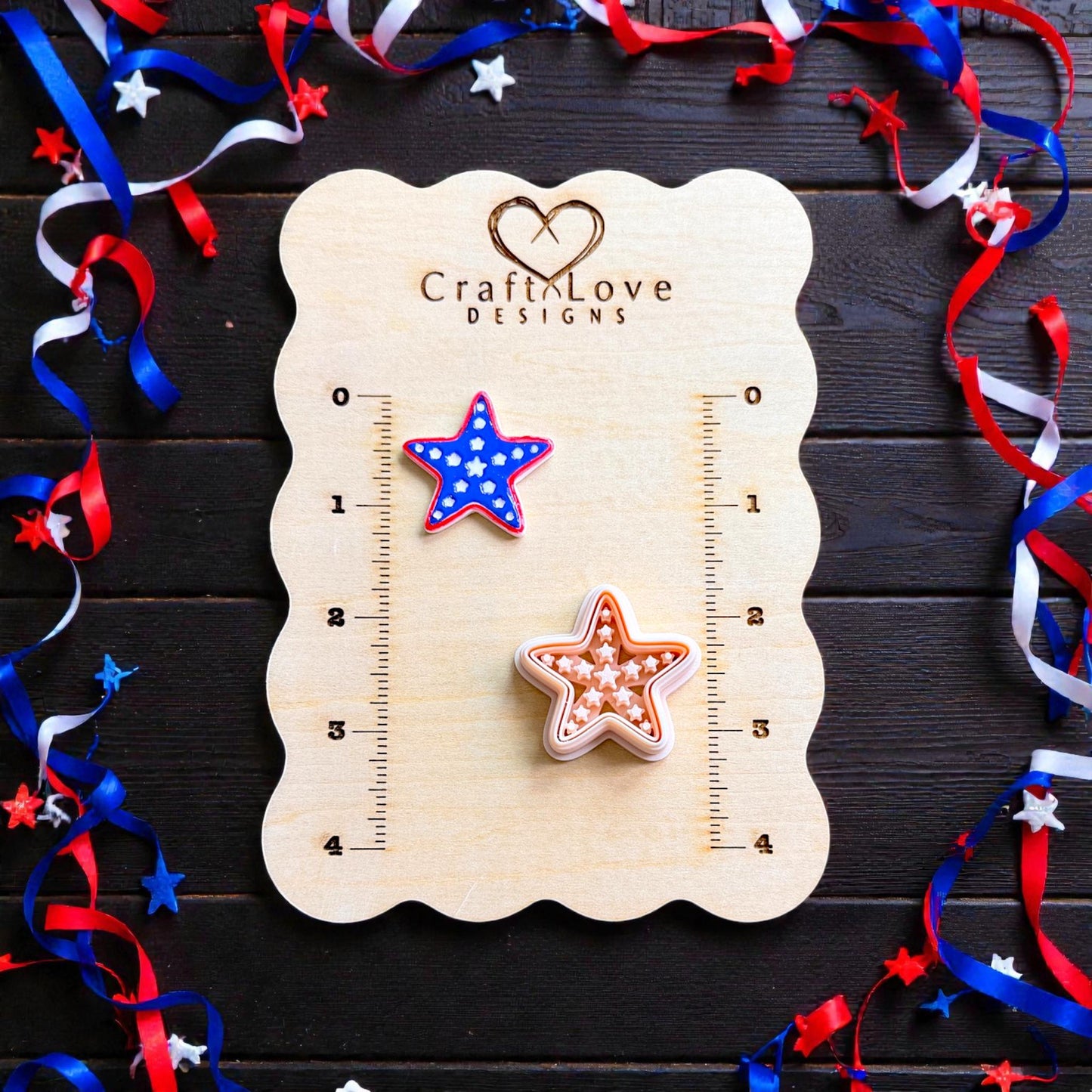 Patriotic starfish polymer clay cutter and finished clay piece displayed on CraftLove Designs measurement board with red white and blue ribbon decor
