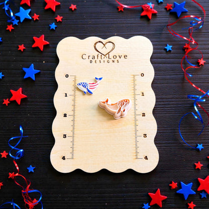 Patriotic whale polymer clay cutter and finished clay design displayed on CraftLove Designs wooden measurement board with patriotic ribbons and stars