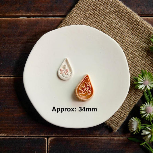 Goose polymer clay cutter and finished clay piece displayed together on white ceramic plate with approximate 34mm size text and floral accents