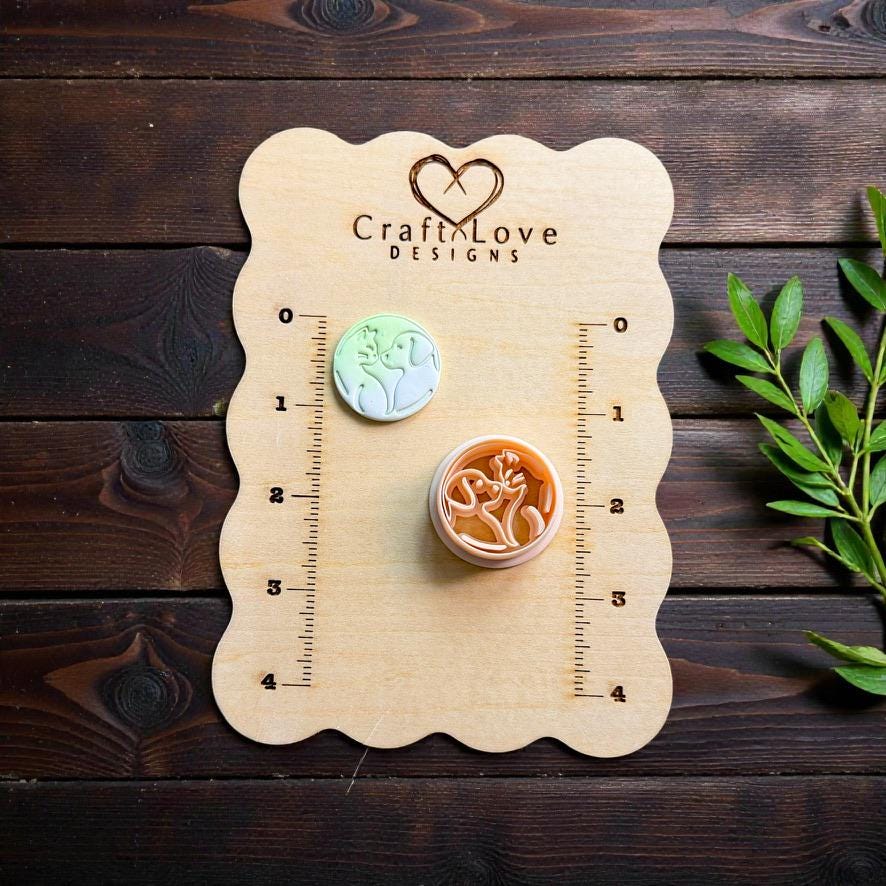 Dog cat polymer clay cutter displayed on wooden measurement board with greenery accents