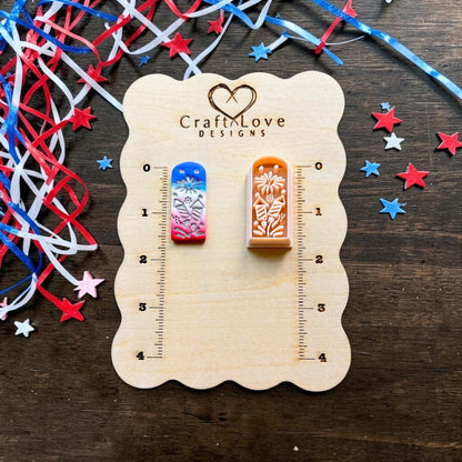 Patriotic fireworks polymer clay cutter displayed on CraftyLove Designs sizing board with red white and blue ribbon decorations