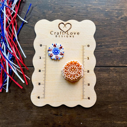 Patriotic sunflower polymer clay cutter and finished red white and blue sunflower example displayed on CraftyLove Designs sizing board