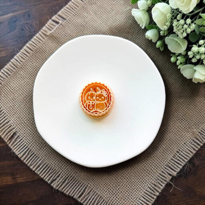 Mr and Mrs Pumpkin polymer clay cutter displayed on a white ceramic dish.
