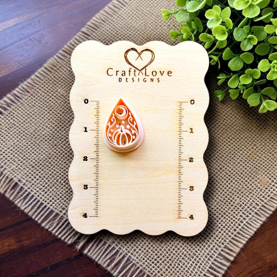 Halloween pumpkin teardrop polymer clay cutter displayed on the Craft Love Designs measurement board.