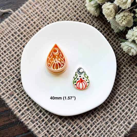 Halloween pumpkin teardrop polymer clay cutter and embossed sample displayed together on a white ceramic dish showing the 40mm (1.57") size.