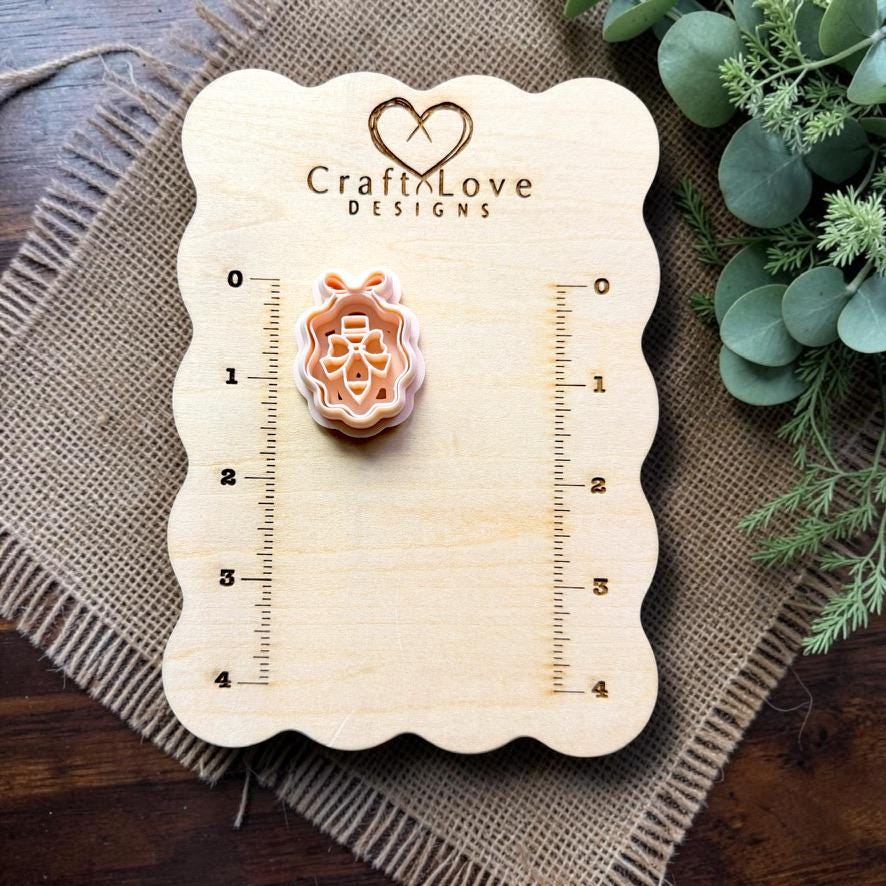 Pencil with bow framed polymer clay cutter displayed on the Craft Love Designs measurement board