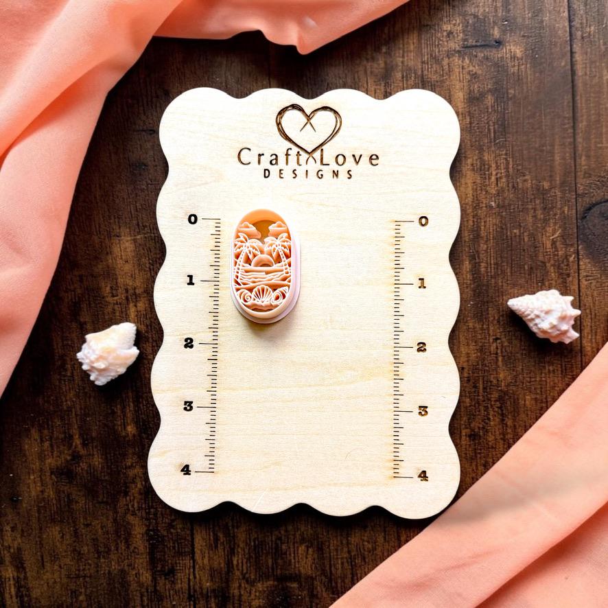 Tropical Beach Sunset polymer clay cutter displayed on a CraftyLove Designs sizing board.
