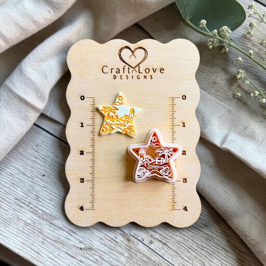 Finished beach scene polymer clay earring and matching cutter displayed on a CraftyLove Designs sizing board