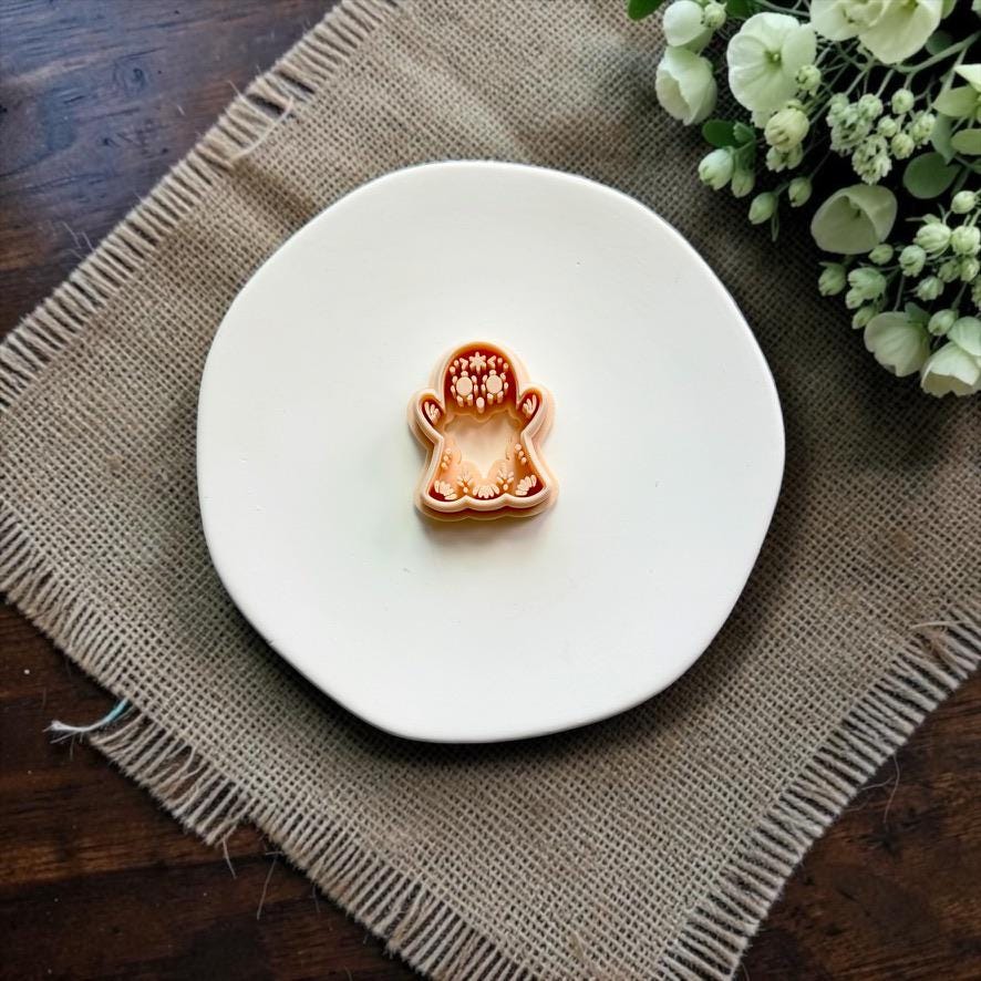 Sugar skull ghost polymer clay cutter on white ceramic dish.