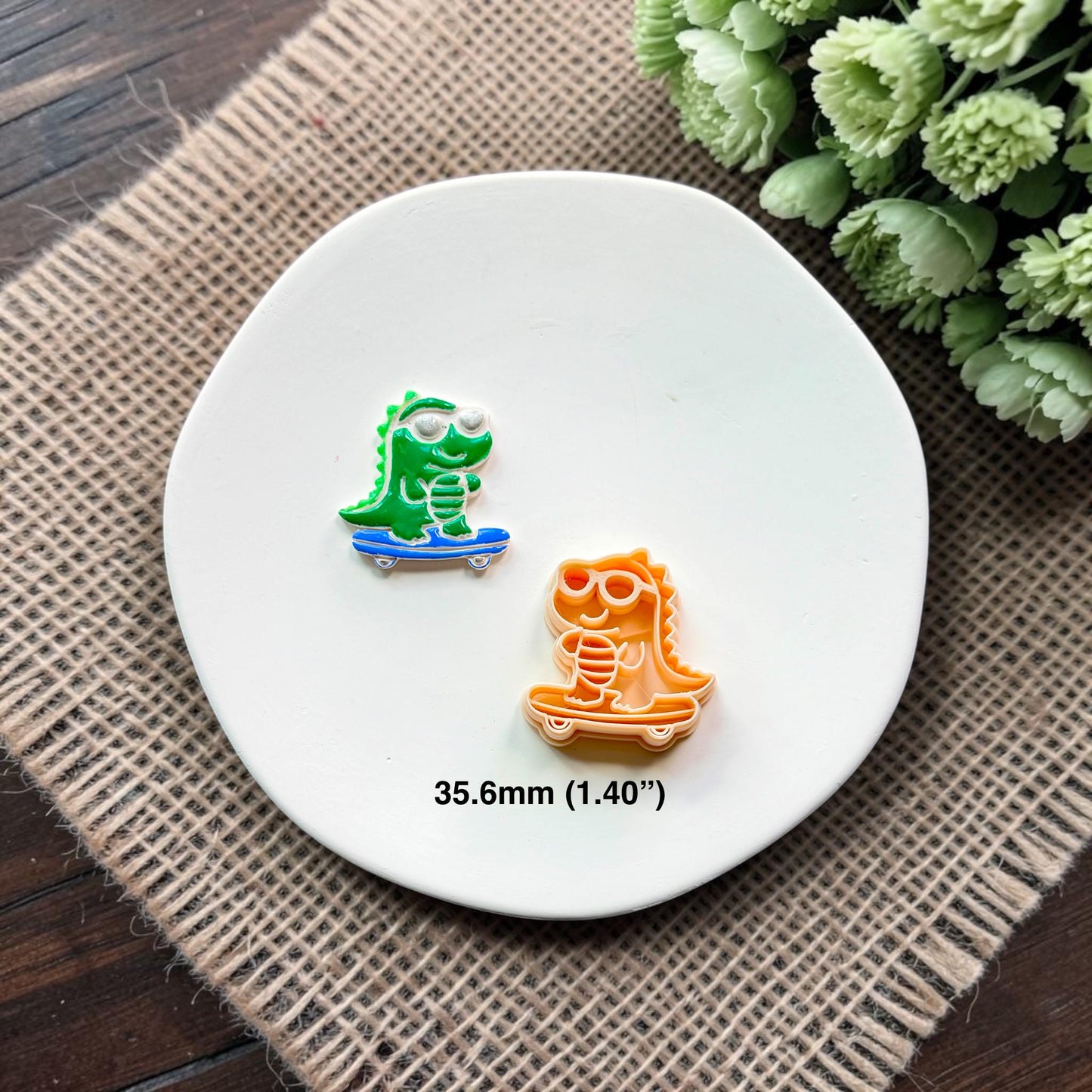 Finished green skateboarding gator clay piece beside the matching polymer clay cutter, with 35.6mm (1.40 inch) size shown.