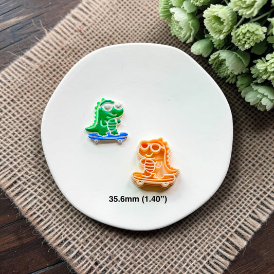 Finished green skateboarding gator clay piece beside the matching polymer clay cutter, with 35.6mm (1.40 inch) size shown.