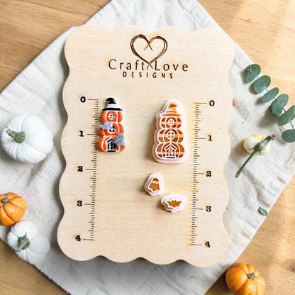 Finished stacked pumpkin Halloween design beside the matching polymer clay cutter set with separate ghost and bat pieces on a measurement board.