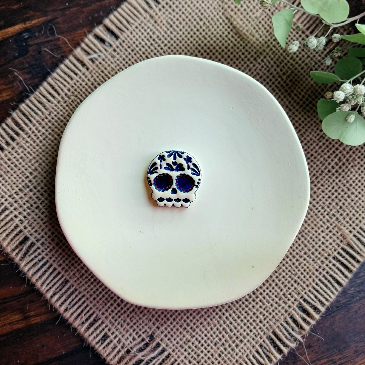 Finished blue and white Sugar Skull clay earring created using the calavera design.
