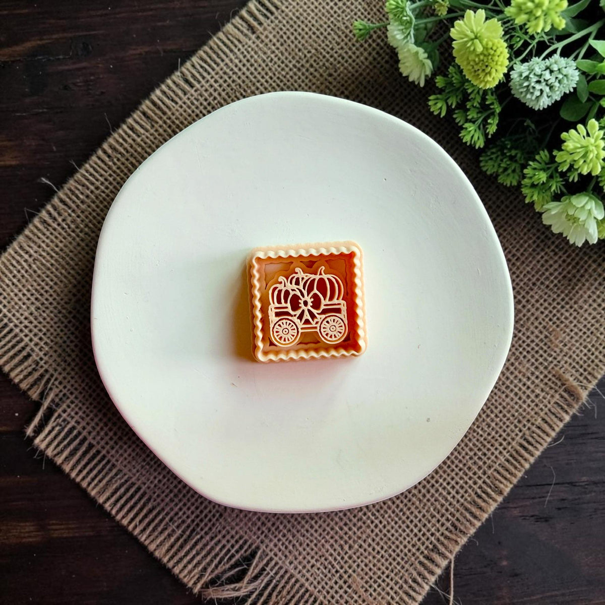 Pumpkin wagon polymer clay cutter displayed alone on a white dish.