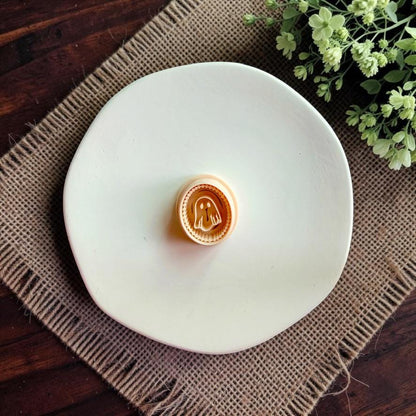 Ghost cameo polymer clay cutter displayed on a white ceramic dish.